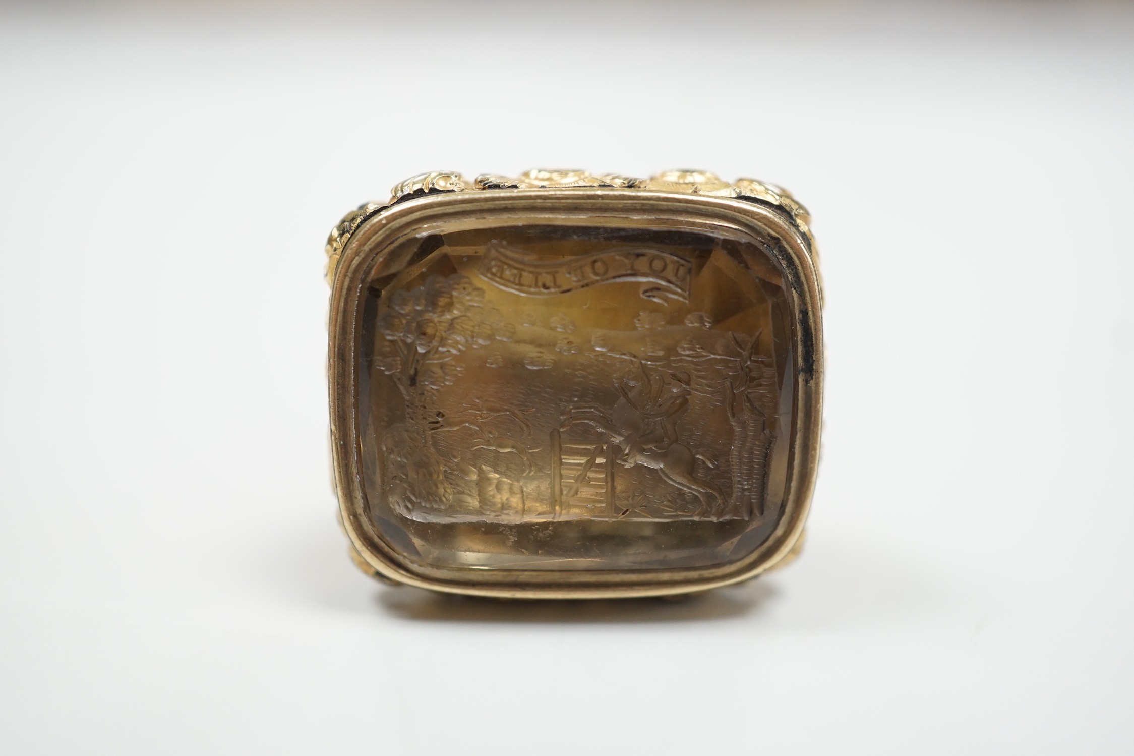 A Victorian yellow metal overlaid mounted citrine fob seal, the matrix carved with fox hunting scene, 34mm.
